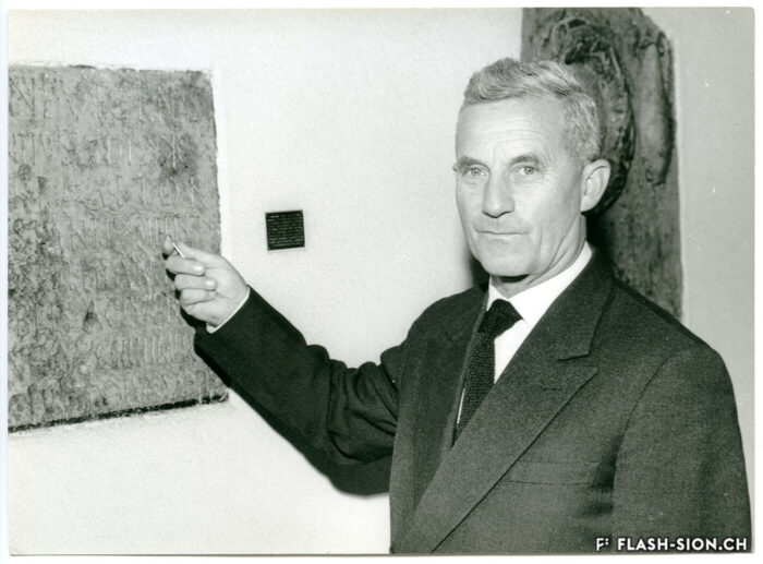 Roger Bonvin dans le vestibule de l’Hôtel de Ville, devant l’inscription d’Asclépiodote, 1962 © PhotoPress AG Zurich, Keystone, Archives de la Ville de Sion – dépôt Charlotte et Monique Bonvin