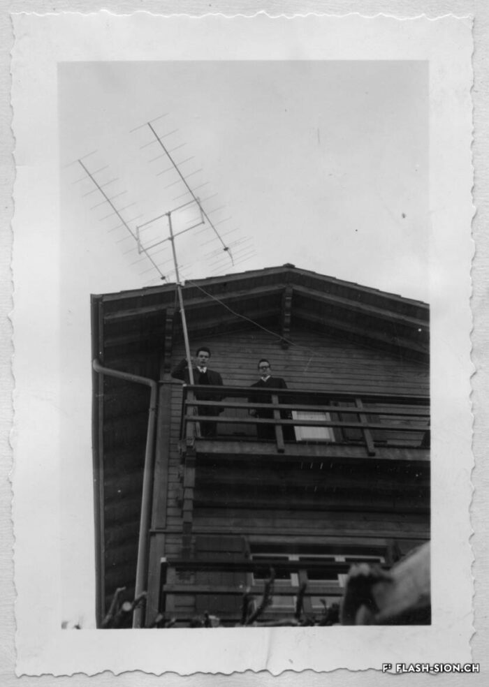 Les premiers tests du réémetteur à Veysonnaz, sur le chalet mis à disposition par la famille Hulliger pour abriter les installations, 1957 © Archives de la Ville de Sion, fonds Michelotti