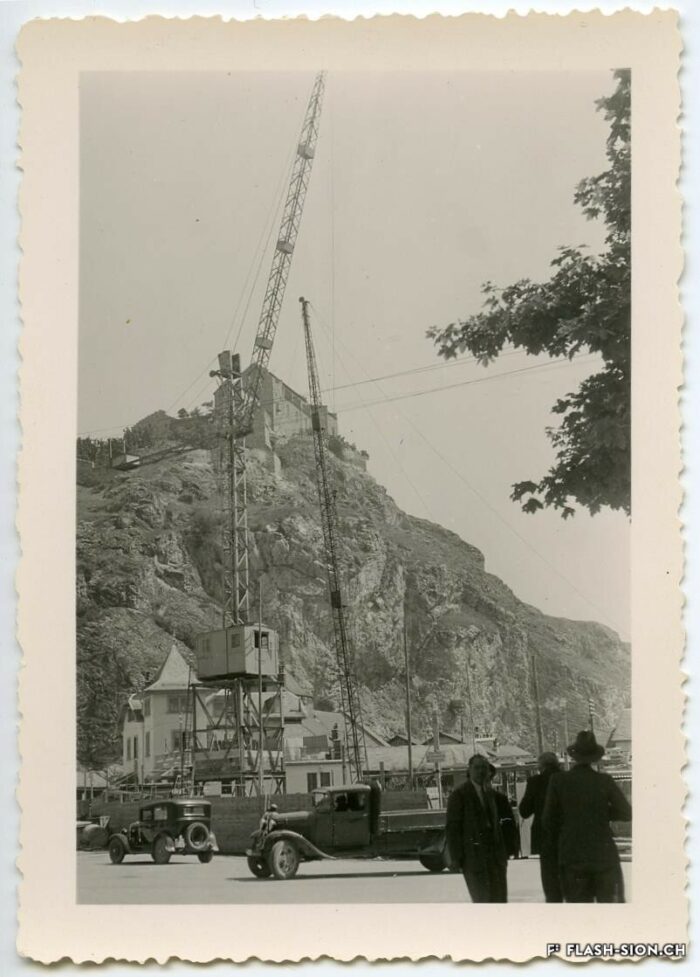 Bâtiment « Les Rochers » en cours de construction avec une grue, machine acceptée, 1937-1938 © Archives de la Ville de Sion