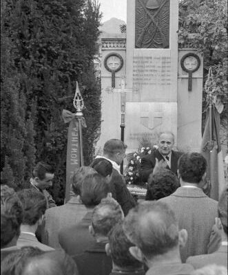 Fête des morts : la communauté italienne devant le monument aux Alpini au cimetière St-François ; les marbriers italiens étaient maitres dans l’exécution de monuments funéraires, 1956 © Raymond Schmid, Bourgeoisie de Sion, Médiathèque Valais-Martigny