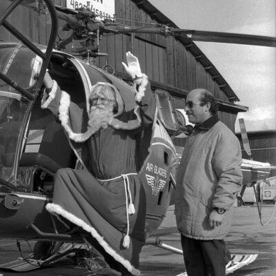 Service peu commun de la société Air-Glacier fondée par Bruno Bagnoud et Hermann Geiger en 1965. Saint-Nicolas prend l’hélicoptère pour une tournée des Grand Magasins « Innovations », 1970 © Philippe Schmid, Médiathèque Valais-Martigny