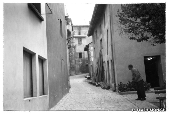 Ruelle Garbaccio, avec la tour des remparts au fond de la rue, 1955, Archives de la Ville de Sion
