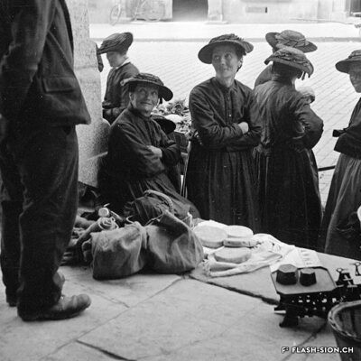 Paysannes sur les marches de la grenette, vendant fromages et autres marchandises lors du marché, vers 1933 © Raymond Schmid, Bourgeoisie de Sion, Médiathèque Valais – Martigny