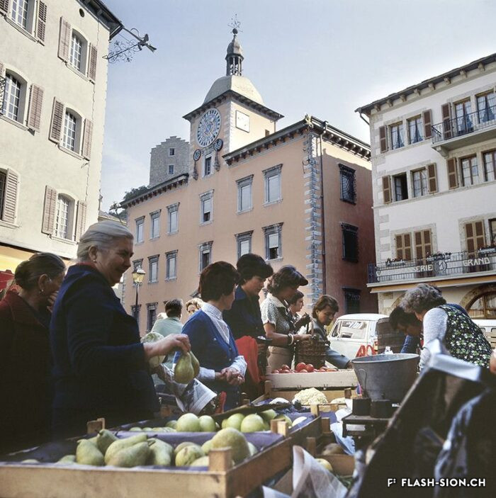 Rue de Conthey, marché aux légumes, vers 1975 © Heinz Preisig, Archives de la Ville de Sion